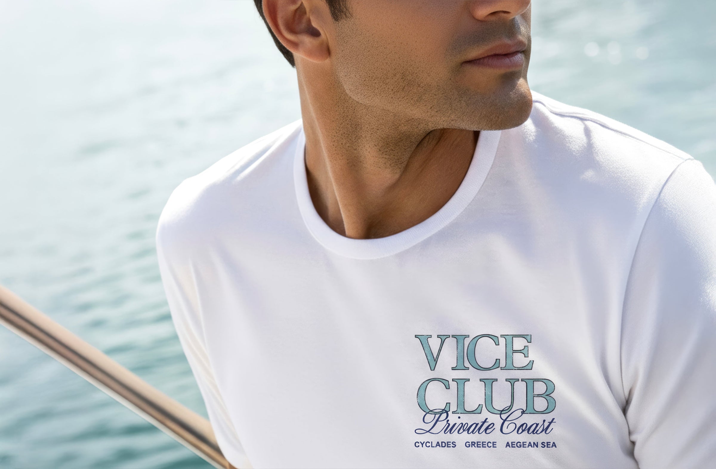 Man wearing white Vice Club t-shirt with Private Coast logo, set on a yacht with ocean background in a refined coastal luxury setting.