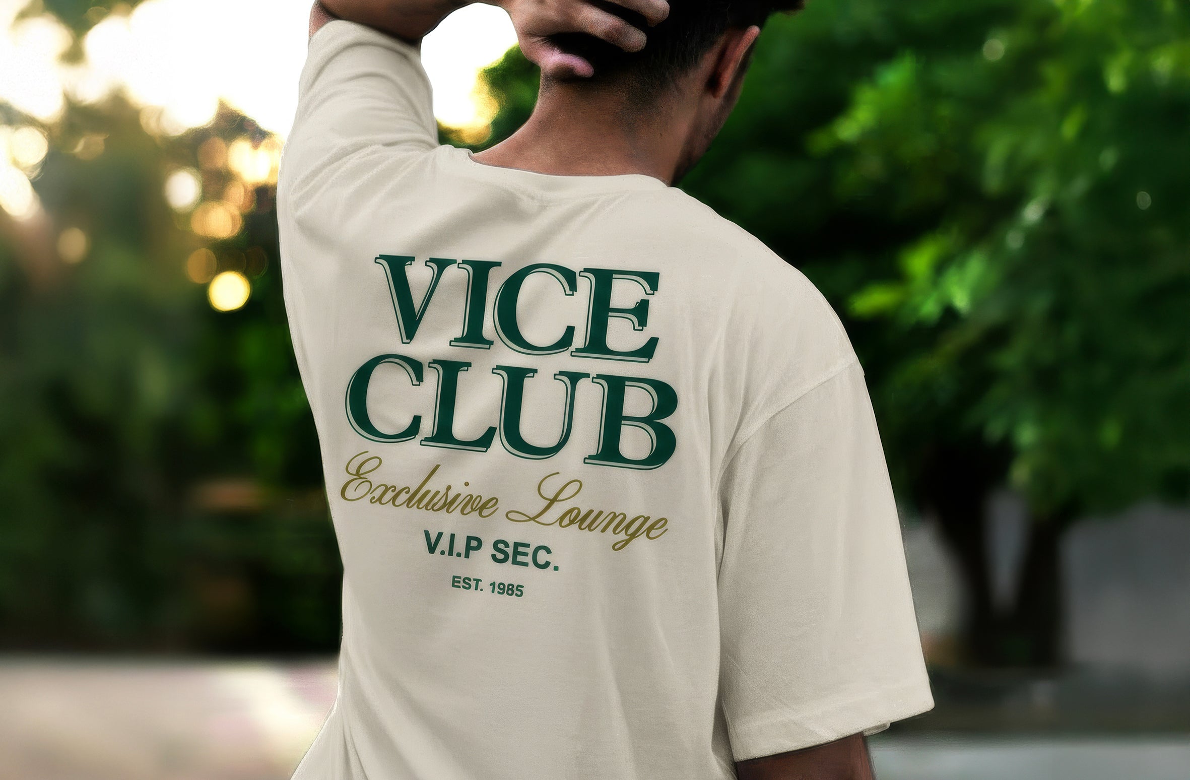 Rear view of man wearing white Vice Club Exclusive Lounge t-shirt with bold back logo, set in a refined VIP nightlife environment.